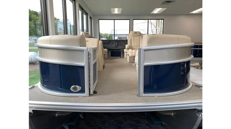 Slide: The Image of 2019 Barletta E20QC pontoon boat interior with beige seating and blue accents. - 2