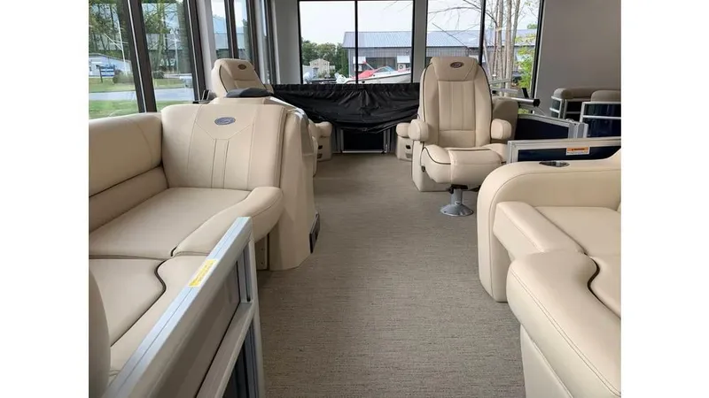 Slide: The Image of 2019 Barletta E20QC pontoon boat interior with beige seating and spacious layout. - 3