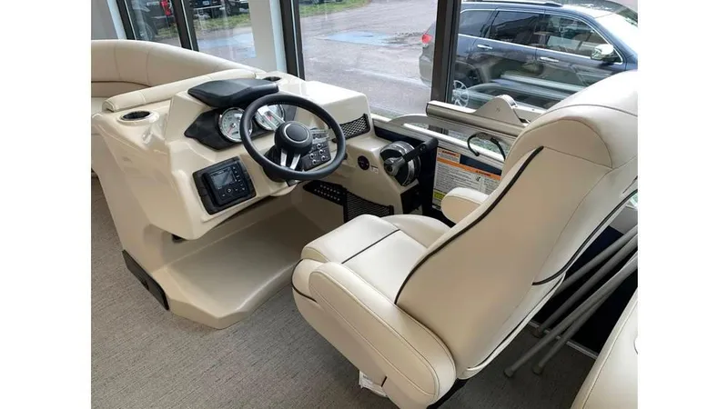 Slide: The Image of 2019 Barletta E20QC boat interior with beige captain's chair and steering console. - 5