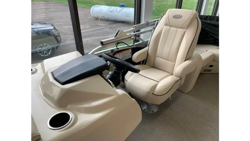 Slide: The Image of Captain's chair in 2019 Barletta E20QC boat interior, featuring beige upholstery and steering console. - 9