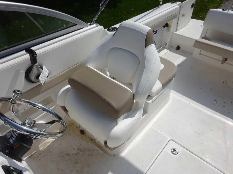 Slide: The Image of 2023 Robalo R227 boat interior with white and beige seating and steering wheel. - 10