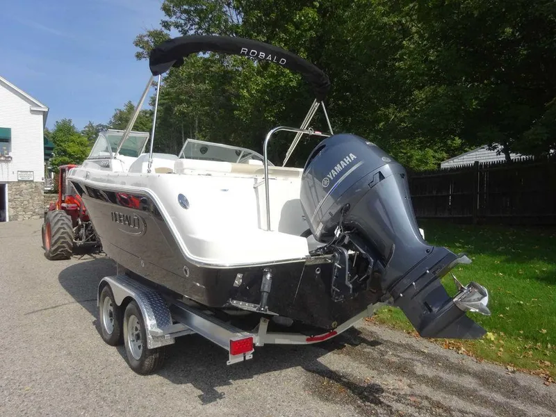 Slide: The Image of 2023 Robalo R227 boat on trailer with Yamaha outboard motor, parked outdoors. - 7