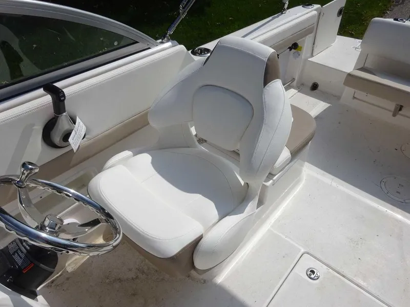 Slide: The Image of 2023 Robalo R227 boat interior with white captain's chair and steering wheel. - 9