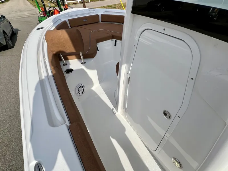 Slide: The Image of 2025 Sea Hunt Ultra 235 SE boat interior with brown seating and white deck. - 11