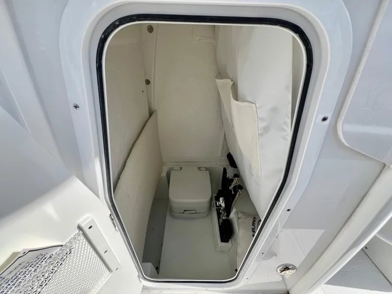 Slide: The Image of 2025 Sea Hunt Ultra 235 SE storage compartment, open hatch, white interior, organized space. - 12