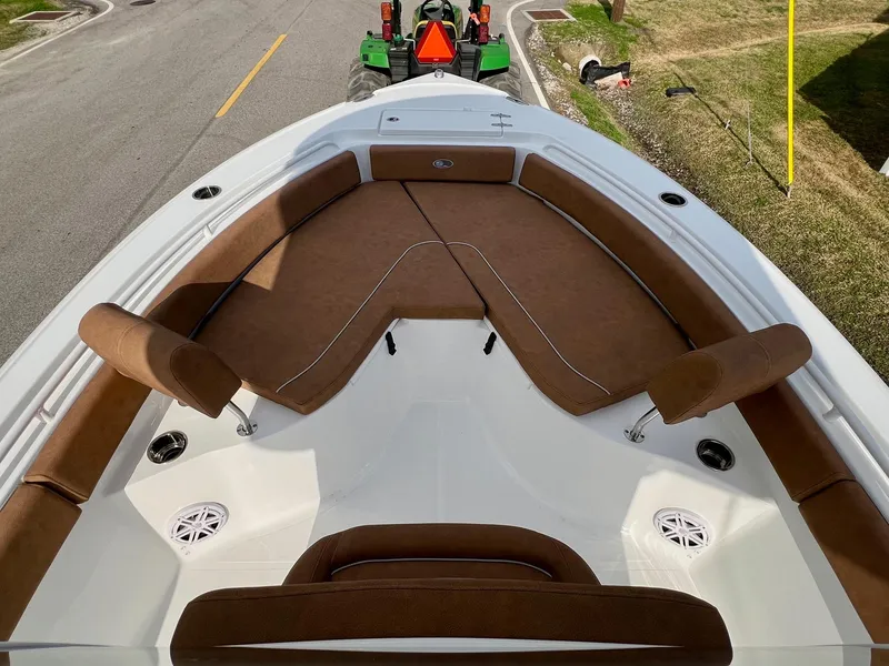 Slide: The Image of 2025 Sea Hunt Ultra 235 SE boat with brown cushioned seating and white deck. - 13