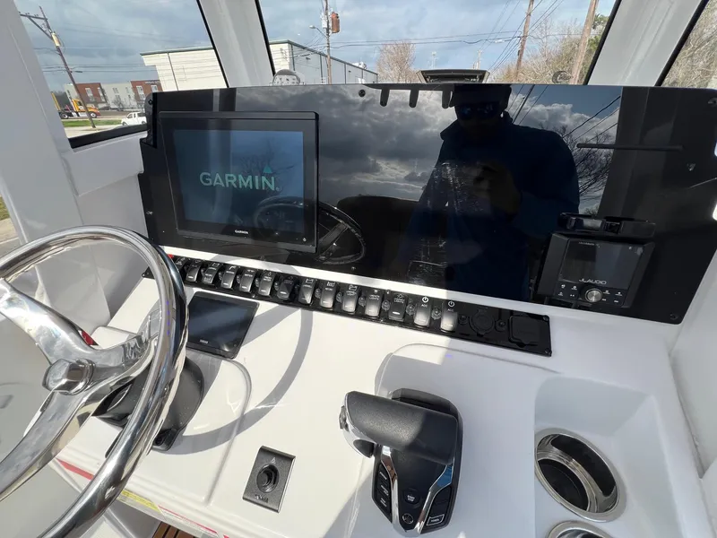 Slide: The Image of 2025 Sea Hunt Ultra 235 SE dashboard with Garmin display and controls. - 16