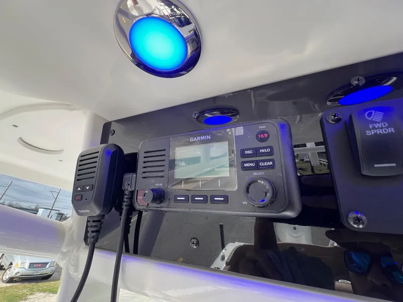 Slide: The Image of 2025 Sea Hunt Ultra 235 SE boat dashboard with Garmin radio and blue LED lights. - 17