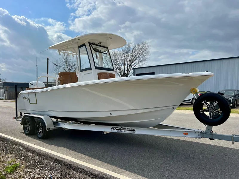Slide: The Image of 2025 Sea Hunt Ultra 235 SE boat on trailer under cloudy sky. - 5