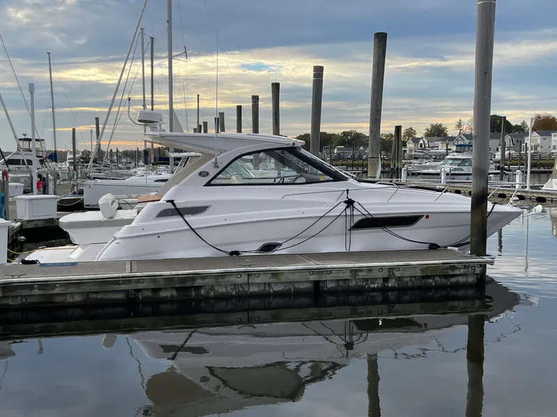 Slide: The Image of 2021 Regal 35 Sport Coupe docked at a marina, reflecting on calm water. - 11