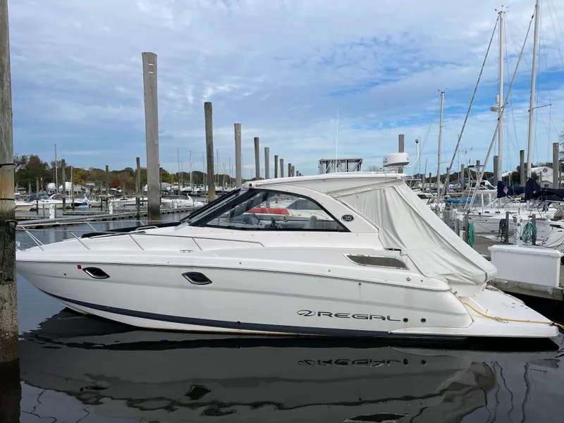 Slide: The Image of 2021 Regal 35 Sport Coupe yacht docked at marina under cloudy sky. - 12