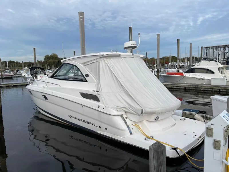 Slide: The Image of 2021 Regal 35 Sport Coupe docked at marina, covered, with calm water reflections. - 13