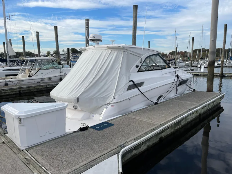 Slide: The Image of 2021 Regal 35 Sport Coupe docked at marina, featuring sleek design and covered cockpit. - 15