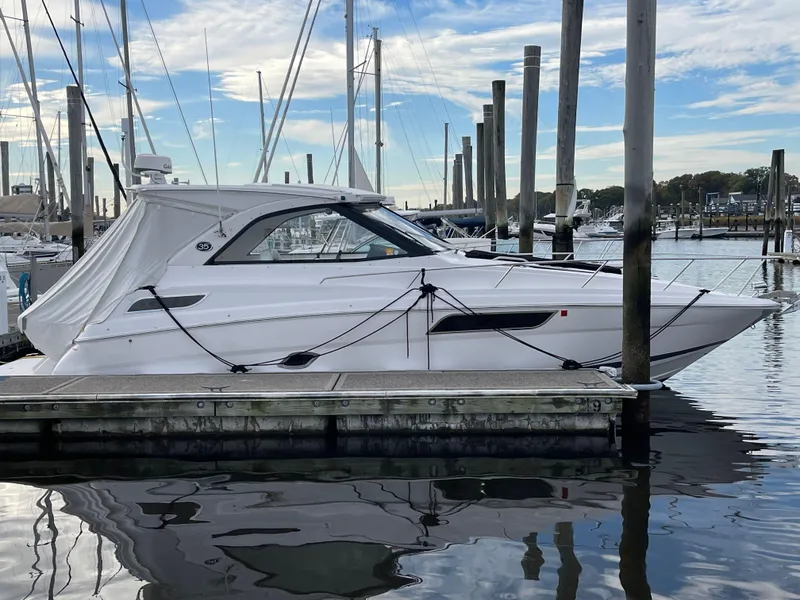 Slide: The Image of 2021 Regal 35 Sport Coupe docked at marina, reflecting on calm water. - 16