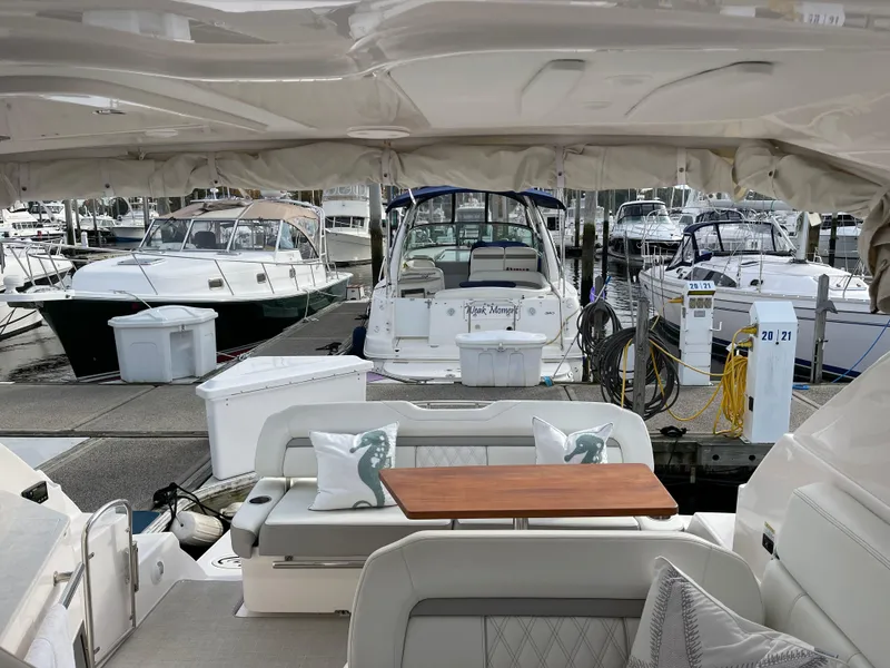 Slide: The Image of 2021 Regal 35 Sport Coupe yacht interior at marina, featuring elegant seating and table. - 18