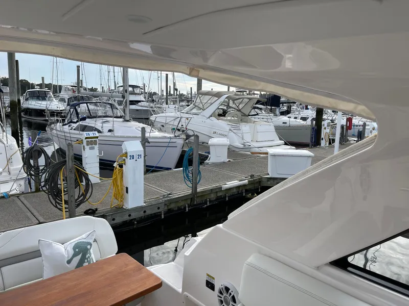 Slide: The Image of 2021 Regal 35 Sport Coupe docked at a marina with other boats. - 19