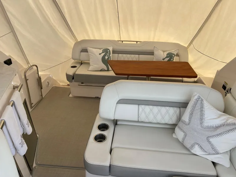 Slide: The Image of 2021 Regal 35 Sport Coupe interior with plush seating, wooden table, and decorative pillows. - 22