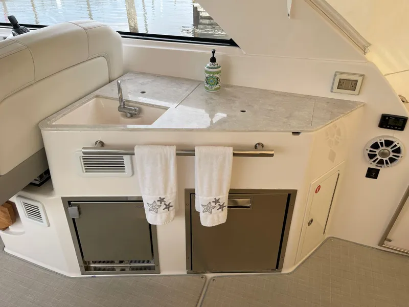 Slide: The Image of Interior of 2021 Regal 35 Sport Coupe featuring a compact kitchenette with sink and storage. - 24