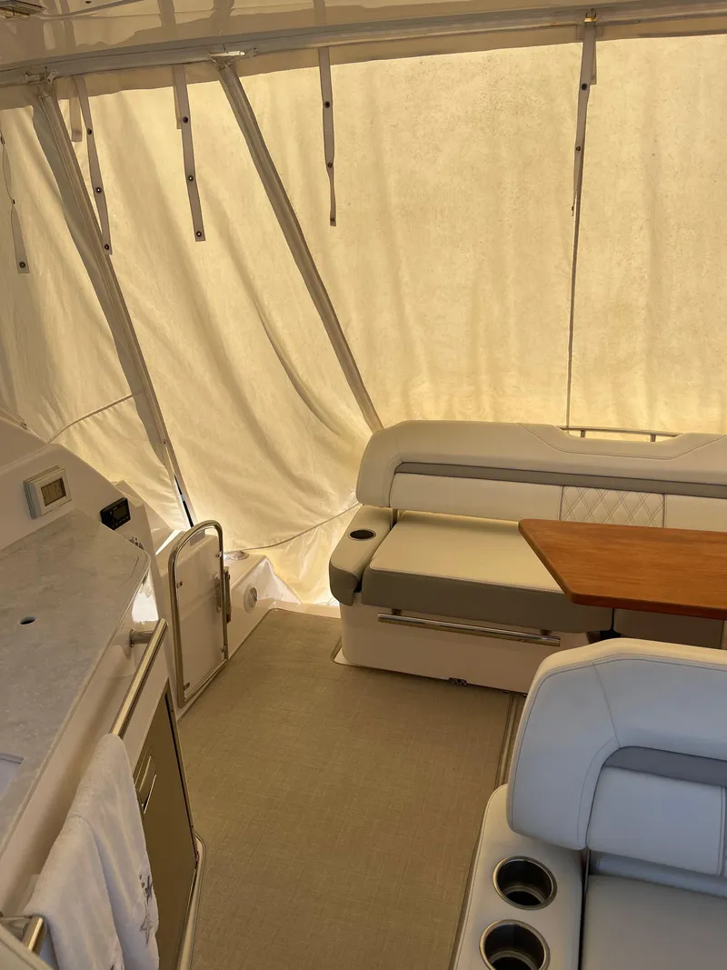 Slide: The Image of 2021 Regal 35 Sport Coupe interior with seating and table, enclosed by curtains. - 25