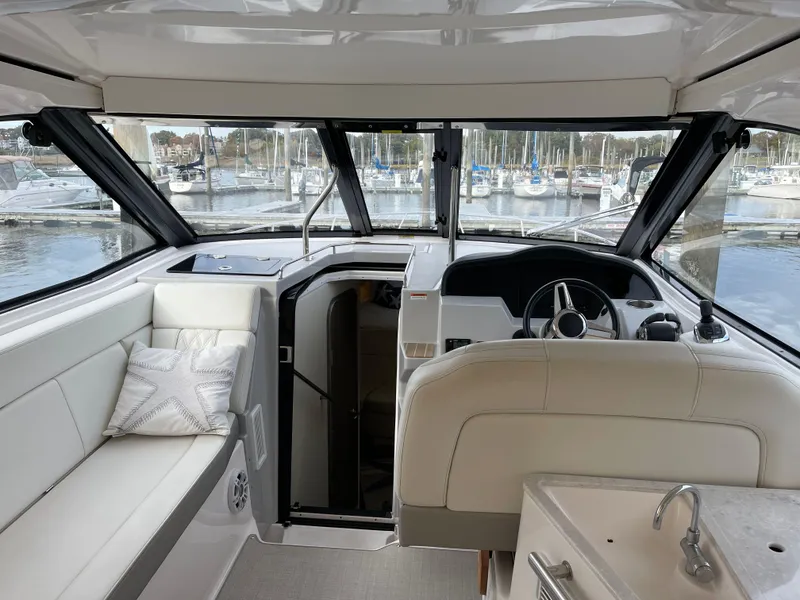 Slide: The Image of Interior of 2021 Regal 35 Sport Coupe yacht with white seating and steering area. - 27