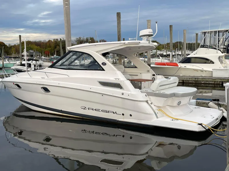 Slide: The Image of 2021 Regal 35 Sport Coupe boat docked in a marina, showcasing sleek design and modern features. - 3