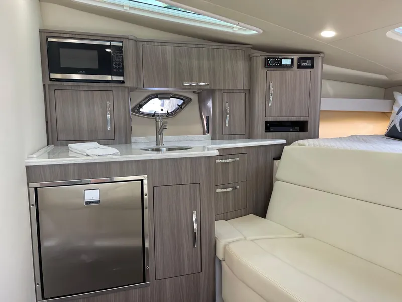 Slide: The Image of 2021 Regal 35 Sport Coupe interior with modern kitchenette and seating area. - 35