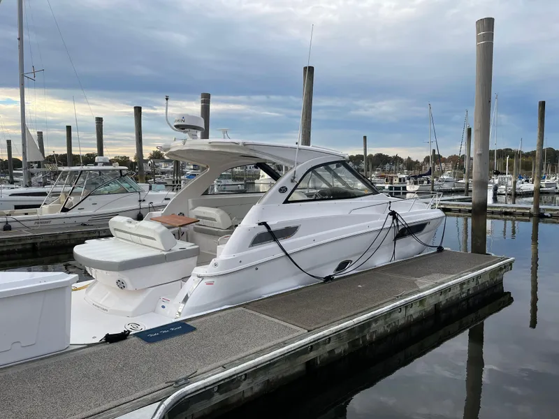 Slide: The Image of 2021 Regal 35 Sport Coupe docked at a marina under a cloudy sky. - 4