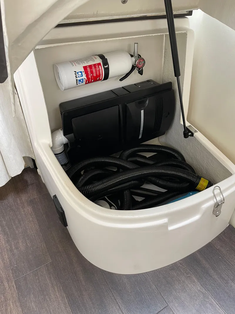 Slide: The Image of Storage compartment in 2021 Regal 35 Sport Coupe with fire extinguisher and hoses. - 47