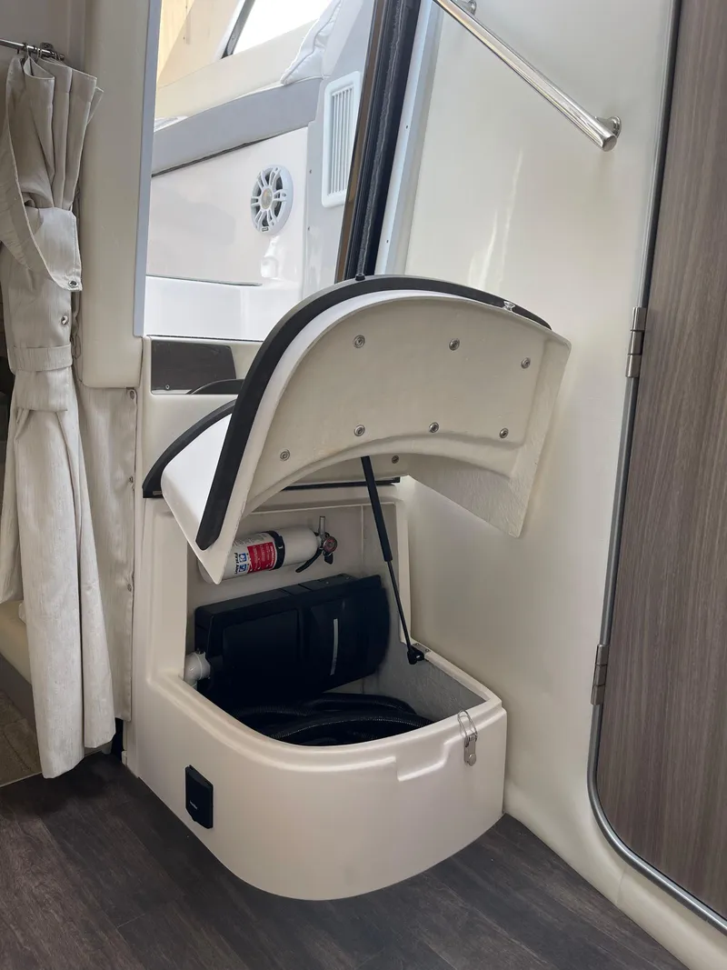 Slide: The Image of 2021 Regal 35 Sport Coupe interior storage compartment with open lid, showcasing organized space. - 48