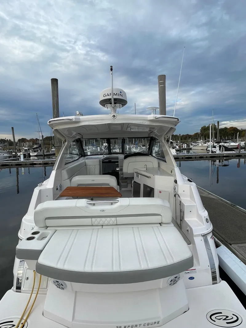 Slide: The Image of 2021 Regal 35 Sport Coupe yacht docked at marina under cloudy sky. - 7