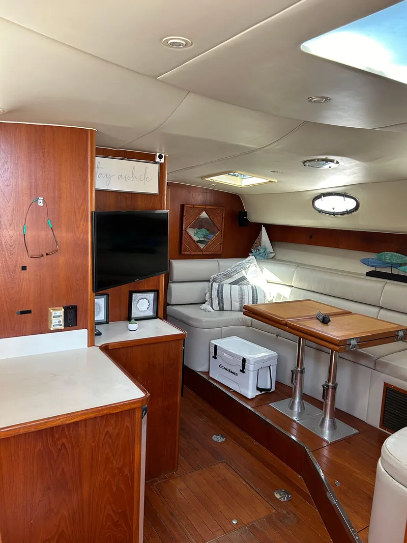 Slide: The Image of Interior of 1997 Tiara Yachts 4000 Express, featuring wood cabinetry and comfortable seating. - 10
