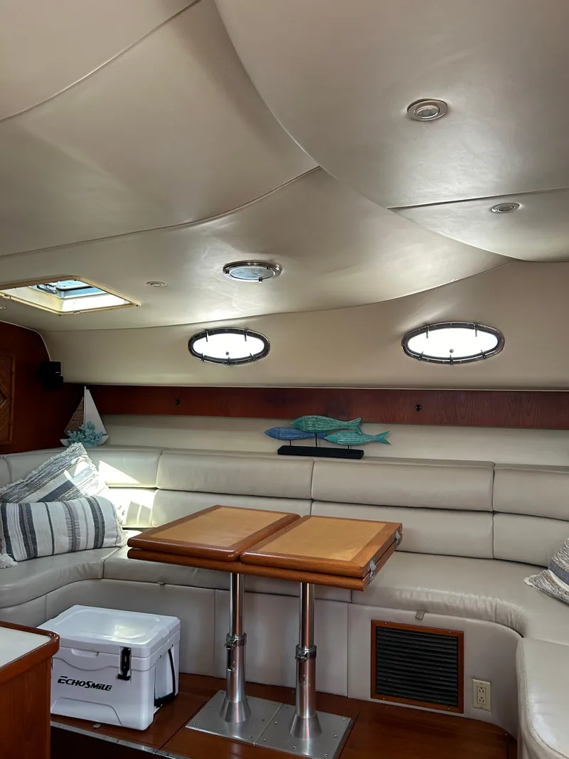 Slide: The Image of Interior of 1997 Tiara Yachts 4000 Express with plush seating and wooden table. - 11