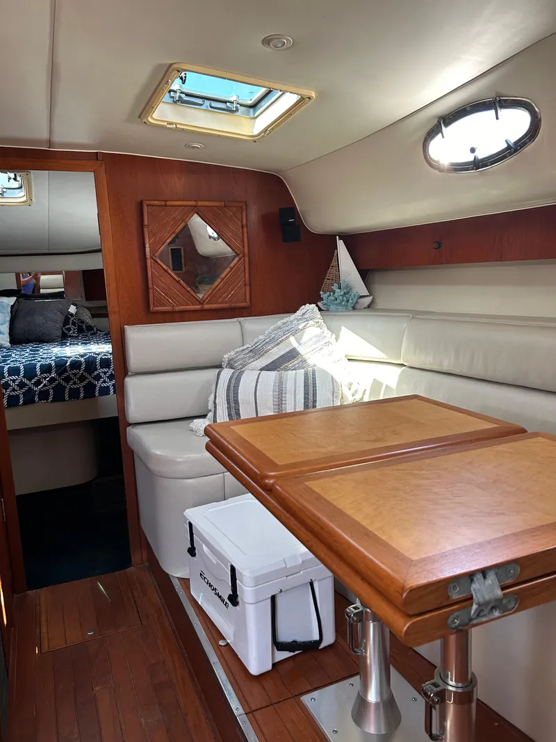 Slide: The Image of 1997 Tiara Yachts 4000 Express interior with seating, table, and cabin view. - 14