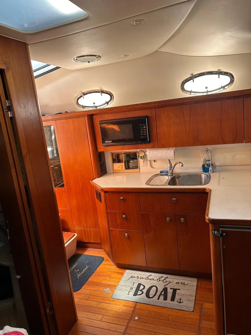 Slide: The Image of 1997 Tiara Yachts 4000 Express interior with wooden cabinetry and modern amenities. - 15