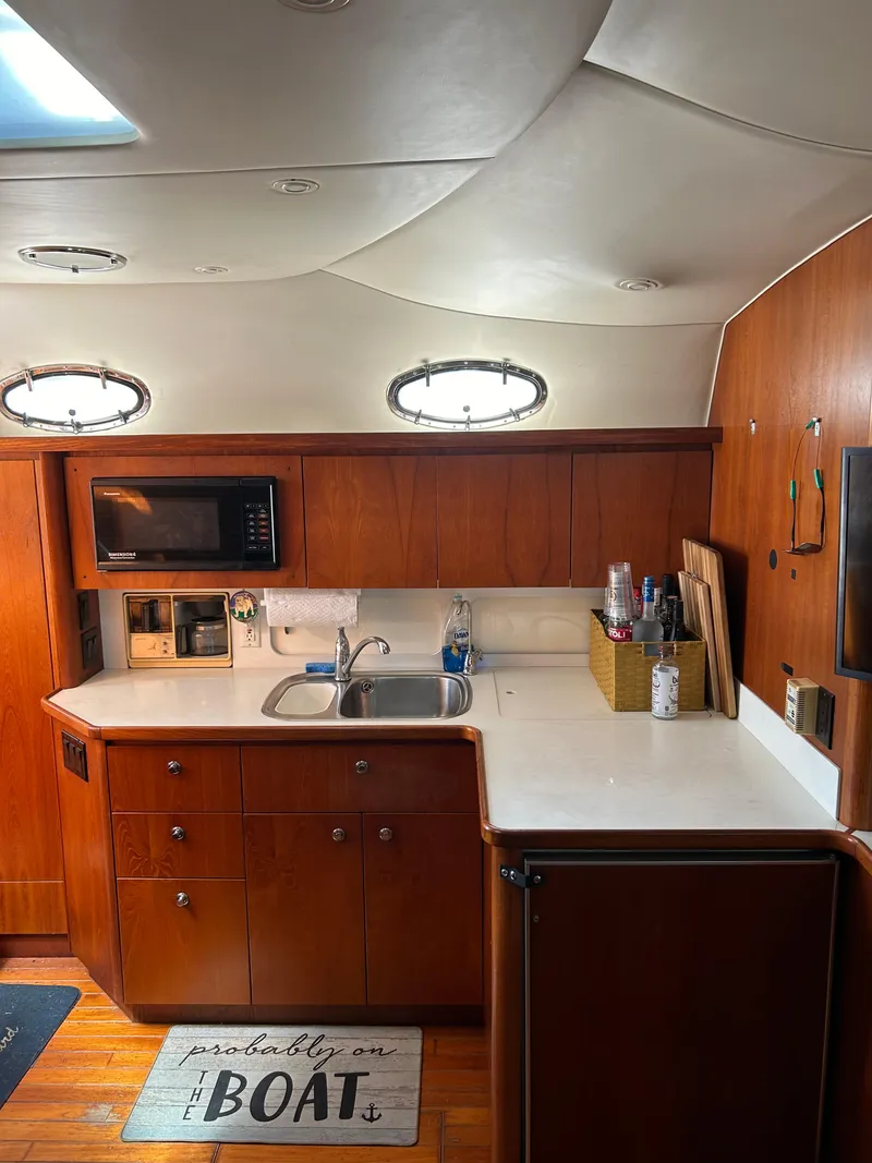 Slide: The Image of 1997 Tiara Yachts 4000 Express interior kitchen with wood cabinets and modern amenities. - 16