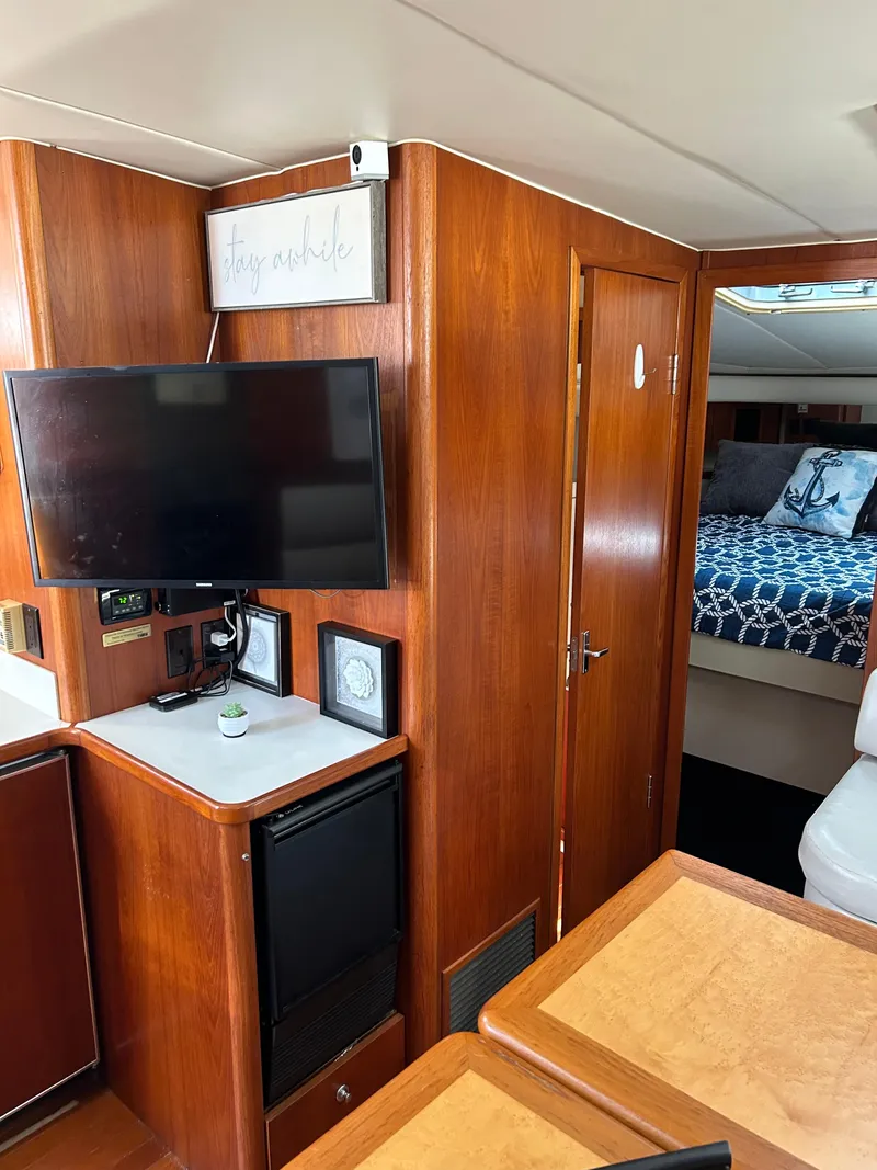 Slide: The Image of Interior of 1997 Tiara Yachts 4000 Express with TV, wood paneling, and cozy bedroom. - 18