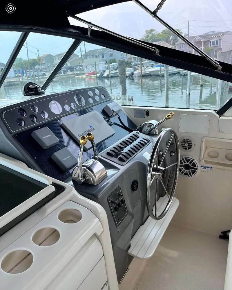 Slide: The Image of 1997 Tiara Yachts 4000 Express helm with controls and steering wheel, dockside view. - 8