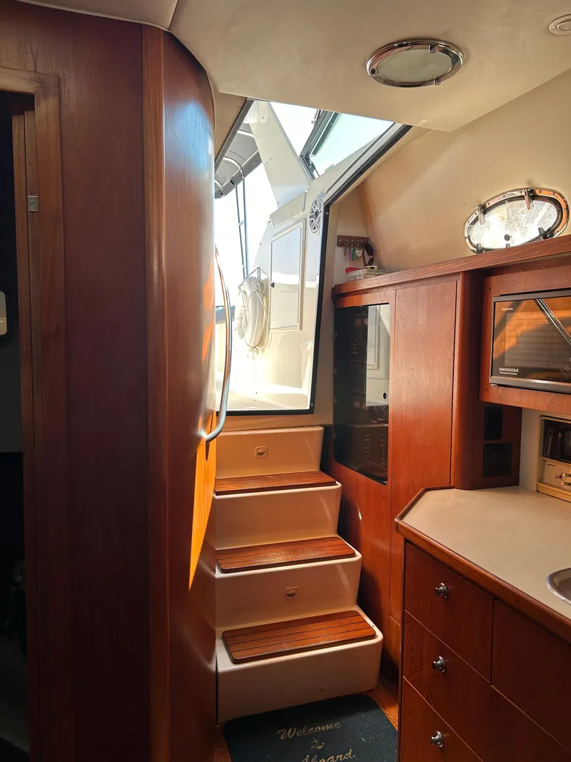 Slide: The Image of Interior of 1997 Tiara Yachts 4000 Express, featuring wooden cabinetry and stairs. - 9