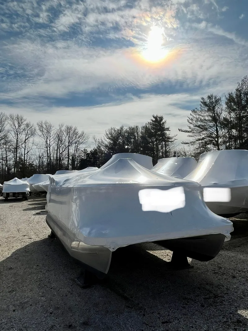 Slide: The Image of 2018 Bennington SX20 pontoon boat covered in white tarp under a sunny sky. - 3