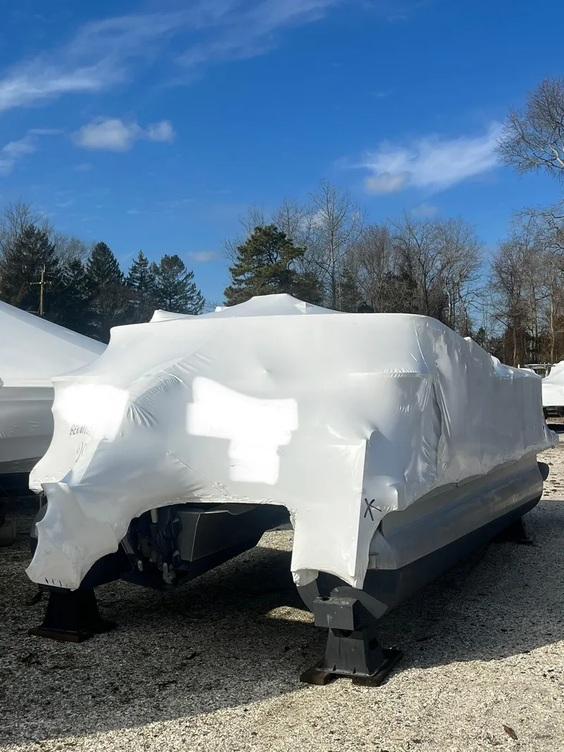 Slide: The Image of 2018 Bennington SX20 boat wrapped in protective cover, stored outdoors on a clear day. - 4
