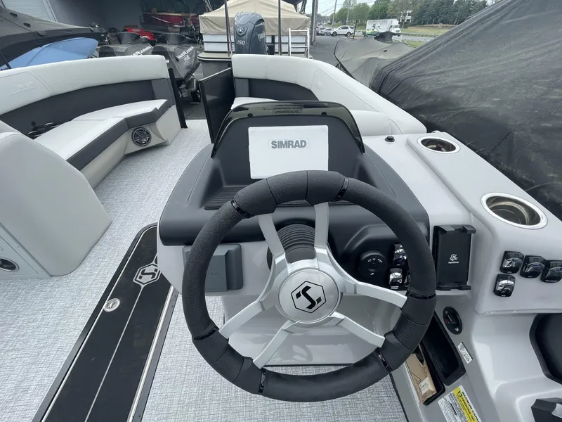 Slide: The Image of 2025 Harris Cruiser 230 boat interior with steering wheel and Simrad navigation system. - 10