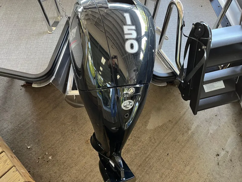 Slide: The Image of 2025 Harris Cruiser 230 with 150 HP outboard motor, docked on concrete surface. - 16