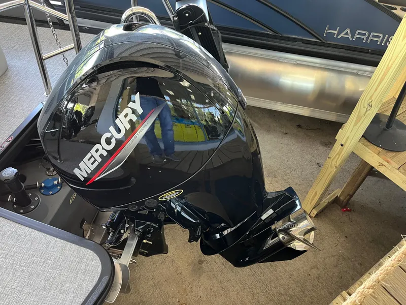 Slide: The Image of 2025 Harris Cruiser 230 with Mercury outboard motor, docked on a wooden platform. - 17