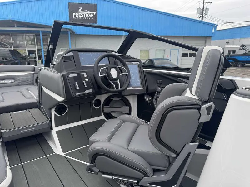 Slide: The Image of 2025 Supra SL boat interior with modern dashboard and seating at Prestige Water Sports. - 13