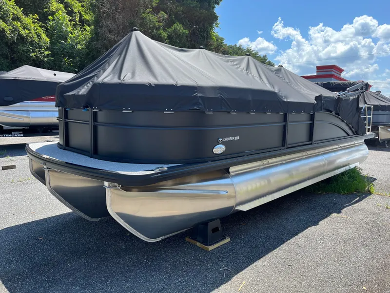 The Image of 2025 Harris Cruiser 230 pontoon boat covered, parked outdoors on a sunny day. - 0