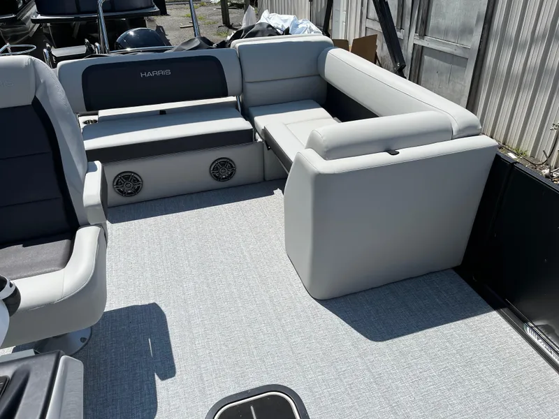 Slide: The Image of 2025 Harris Cruiser 230 interior with gray seating and built-in speakers. - 11