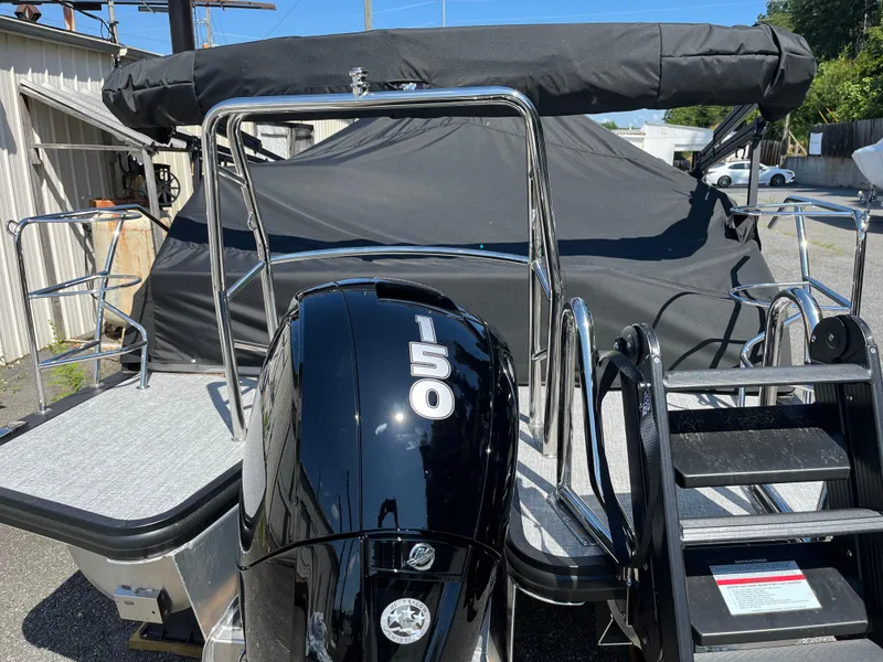 Slide: The Image of 2025 Harris Cruiser 230 boat with a 150 horsepower engine, covered and docked. - 5