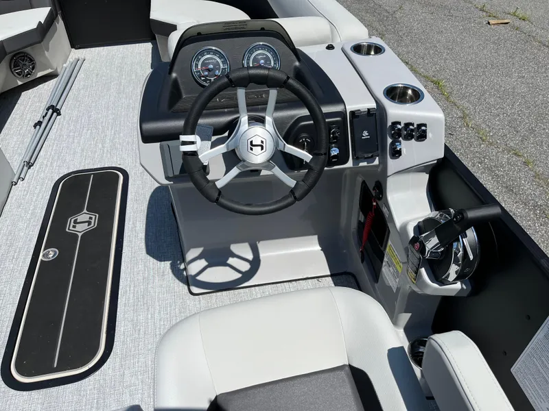 Slide: The Image of 2025 Harris Cruiser 230 boat dashboard with steering wheel and controls. - 7