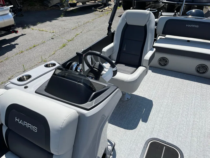 Slide: The Image of 2025 Harris Cruiser 230 boat interior with steering console and seating. - 9