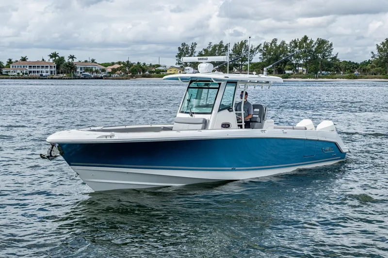 Slide: The Image of 2023 Boston Whaler 330 Outrage boat cruising on a calm waterway. - 10